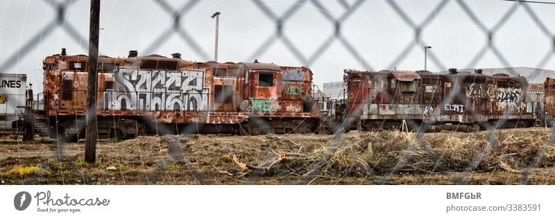 besprayte Zugwagen hinter einer Absperrung Zugabteil Sprayerei gitterzaun transportmittel Eisenbahn Bahnfahren Menschenleer Tag Schienenverkehr Verkehr