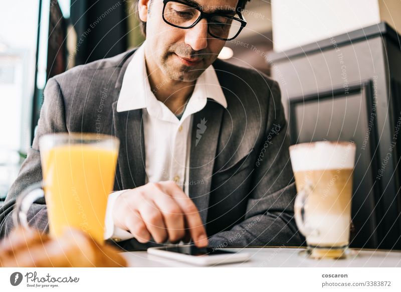 Geschäftsmann an der Bar bei einer Tasse Kaffee und Orangensaft Erwachsener Anwendung Frühstück Business Café heiter Mitteilung trinken Exekutive Ausdrücken