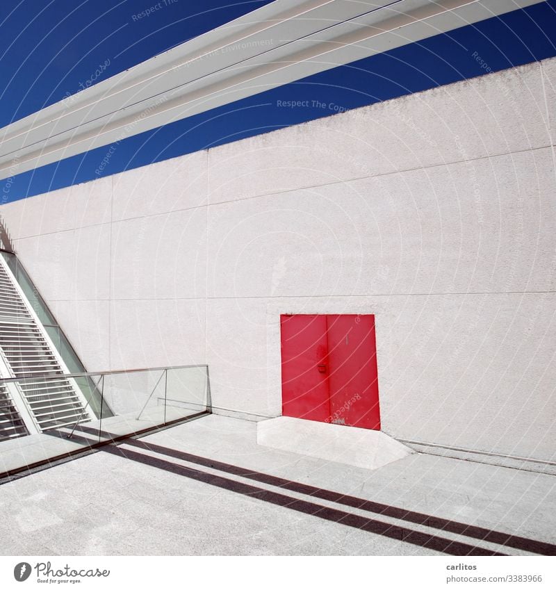 Rote Tür an weißer Wand mit blauer Linie unter blauem Himmel Fassade Tor rot Markierung Linien Fugen Schatten Geländer Glas Lamellen Sonnenschutz menschenleer