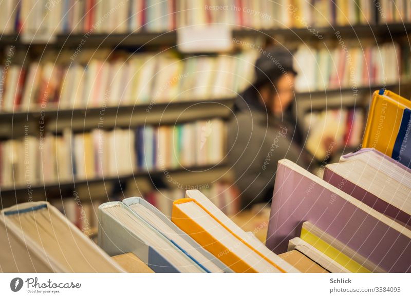 Nahaufnahme second hand Bücher im Buchladen mit Kundin im Unschärfebereich bücher Second-Hand Laden kundin Frau selektiver Focus Bokeh Bücherregal viele