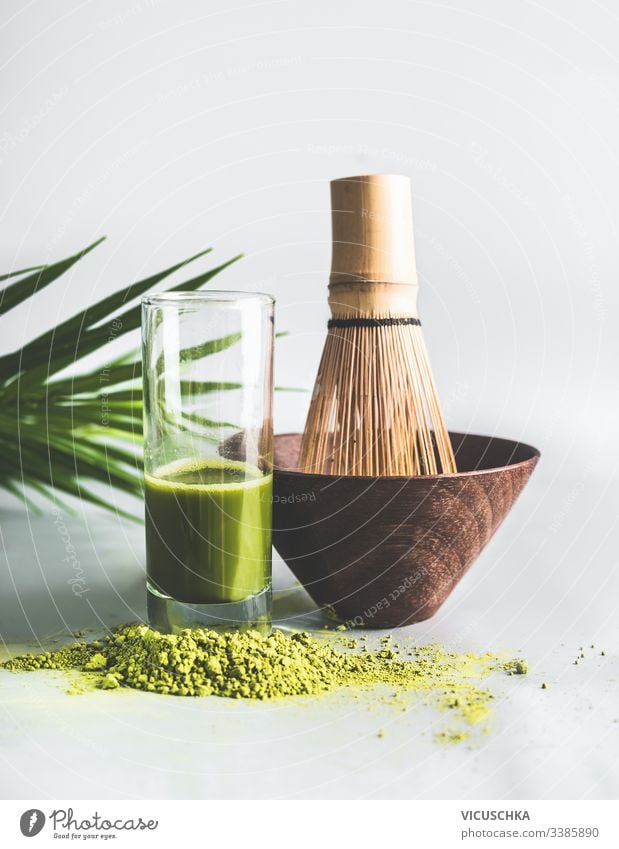 Matcha-Teepulver mit einem Glas Matcha-Espresso und einem Matcha-Besen-Set. Konzept der gesunden Lebensweise Pulver Schneebesen-Set Gesundheit Lifestyle