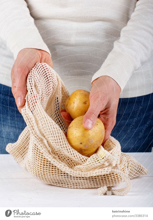 Frau legt frische Kartoffeln in einen Textilbeutel keine Verschwendung Konzept Abschluss setzen Hände gesichtslos Tasche Gemüse Landwirte abschließen null