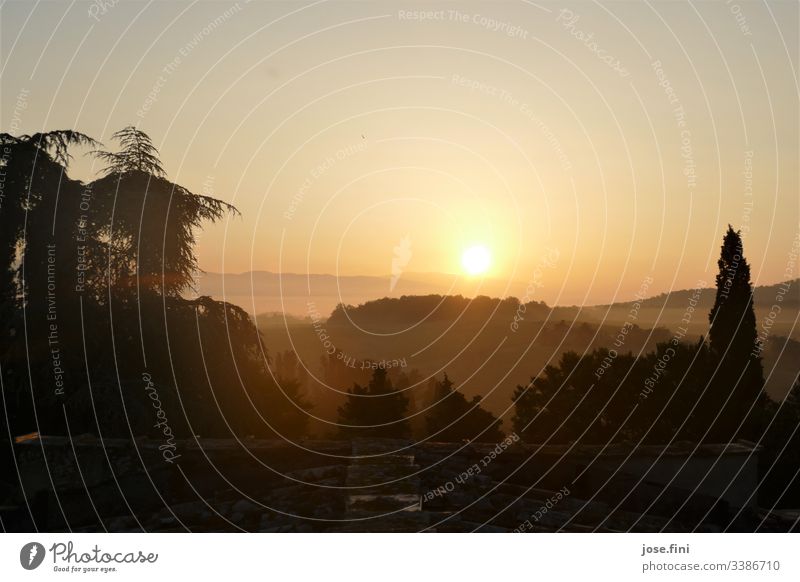 Sonnenaufgang in der Toscana Natur Landschaft Bäume Dach Berge Horizont Himmel Sonnenlicht orange hell Strahlen Außenaufnahme Menschenleer gelb Morgen wolkenlos