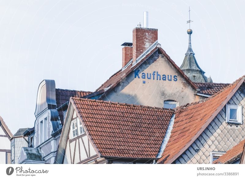 Dächer alter Fachwerkhäuser und Giebel mit der Aufschrift Kaufhaus Dach Baustein Fachwerkhaus Turmspitze Schornsteine Dorf Altstadt Gedeckte Farben High Key Tag