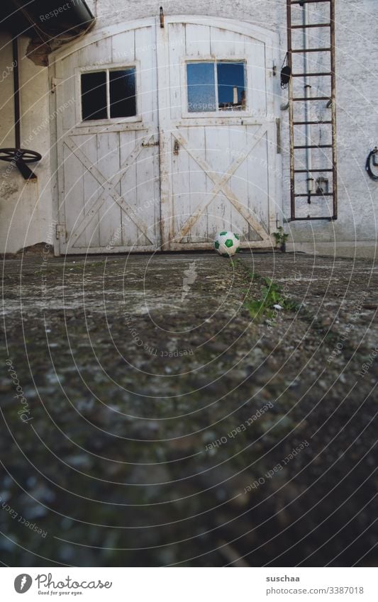 Fußball von einem Tor in einem Hof Tür Eingang Hinterhof Ausgang Detailaufnahme Wand Fassade Außenaufnahme Fenster geschlossen Gebäude Lagerhalle Feuerleiter