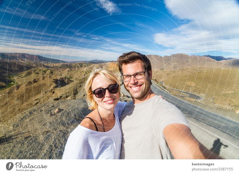 Aktives, glückliches Paar, das sich auf Reisen in das Hochgebirge des Atlas, Ouarzazate, Marokko, begibt. Selfie Abenteuer Porträt Spaß wüst Architektur