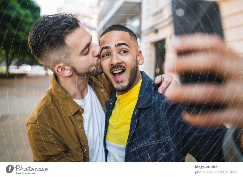 Ein schwules Paar, das sich auf der Straße vergnügt. Liebe Partnerschaft Handy Termin & Datum lieblich positiv Großstadt Freiheit Leben jung Stolz Selfie