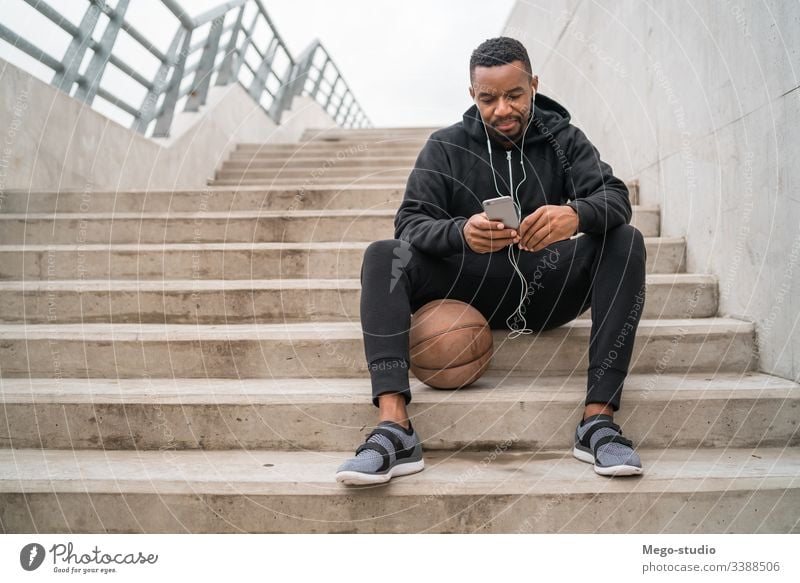 Sportler, der sein Mobiltelefon benutzt. Mann Läufer hören Kopfhörer Training Übung Lifestyle Erwachsener Gesundheit im Freien sportlich Typ laufen Mitteilung