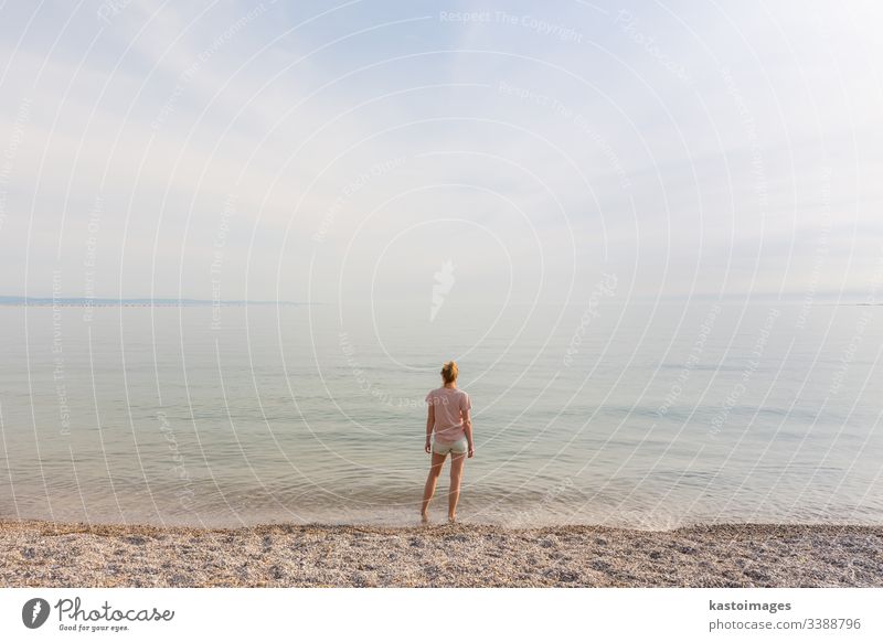 Fröhliche sorglose Frau genießt den Sonnenuntergangsspaziergang am weißen Pabbled Beach. Strand MEER Mädchen Glück Natur jung Sommer Wasser Meer schön Urlaub