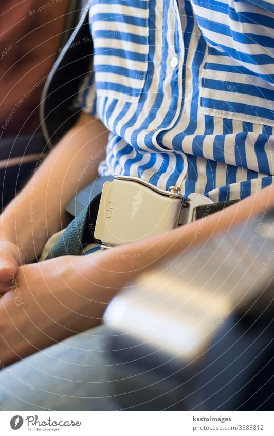 Weibliche Passagierin mit angeschnalltem Sicherheitsgurt, während sie im Flugzeug sitzt, für einen sicheren Flug. Sitz reisen Frau Fliege Verkehr Mädchen Ebene