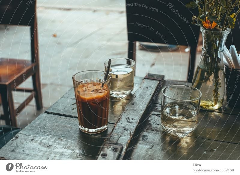 Vietnamesischer Eiskaffee auf einem Holztisch in einem Café draußen in retro Farbgebung Kaffee holz kaffeepause aromatisch Morgen Getränk Koffein altehrwürdig