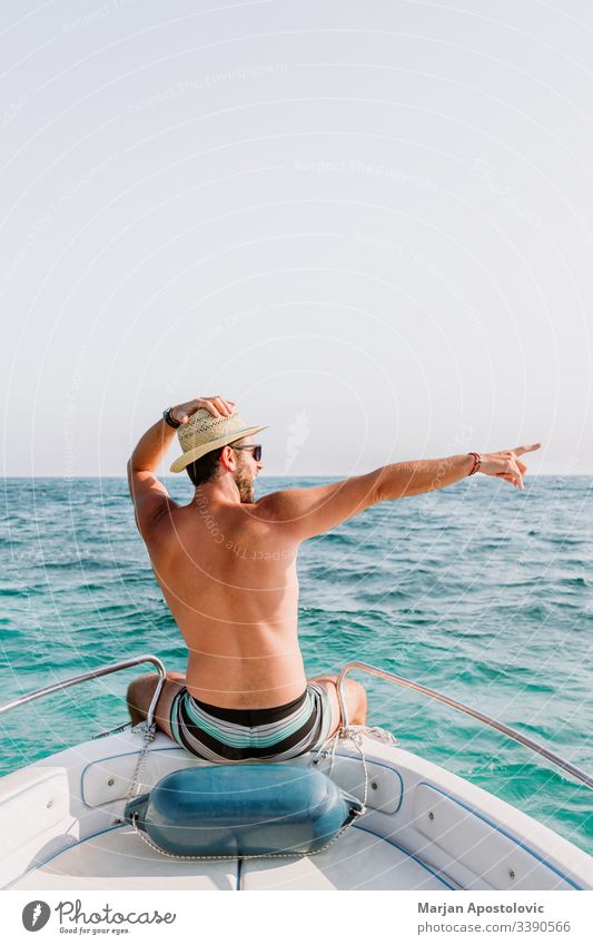 Junger Mann am Bug des Bootes, der den Blick auf das Meer genießt Erwachsener Abenteuer ägäisch Waffen blau Schleife Kreuzfahrt Tag Schiffsdeck genießend frei