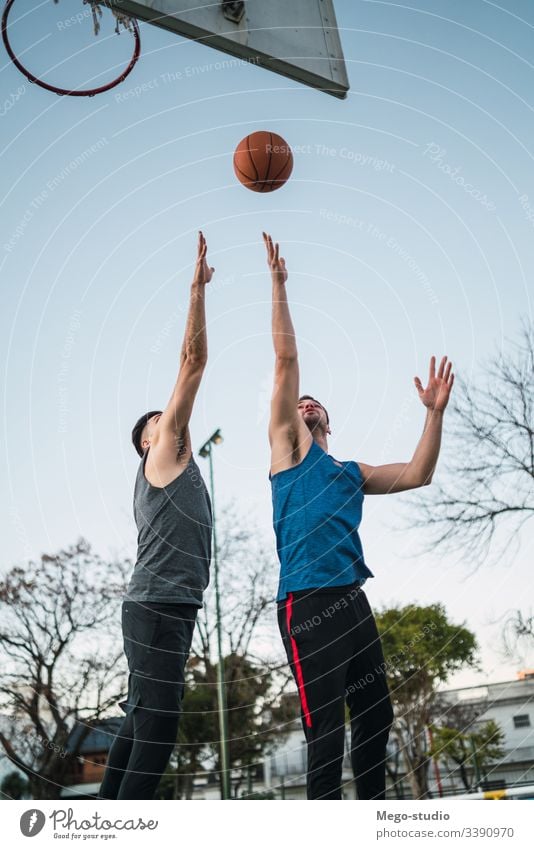 Zwei junge Freunde spielen Basketball. Spiel Jugend Sport Ball Gericht männlich Korb Team Zusammensein aktiv Aktion Spielplatz Übung Männer Freundschaft