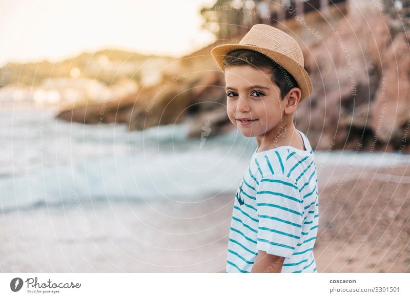 Kleiner Junge mit Hut, der am Strand auf das Meer schaut Rücken Hintergrund schön blau Kind Kindheit Kinder Küste Kontemplation niedlich genießend Mode modisch