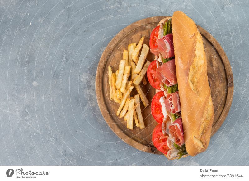 Sandwich Serranito typisch in Andalusien mit Schinken, Paprika und gegrillter Schweinelende Andalusia Speck bocadillo Brot Frühstück grüner Pfeffer Italienisch