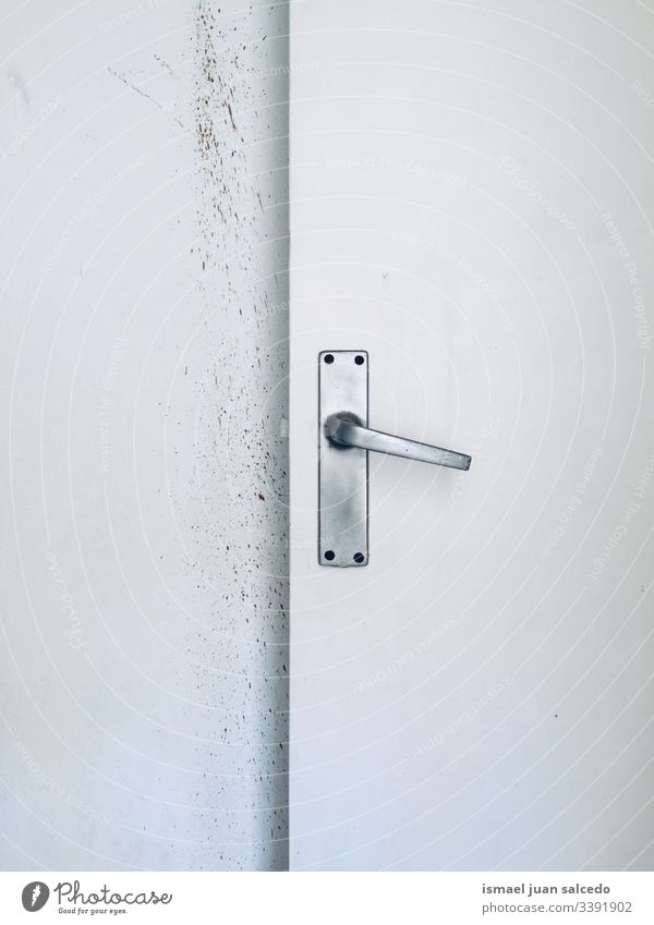 alte weiße Tür im weißen und schmutzigen Raum hölzern dreckig Schmutz im Innenbereich sehr wenige Wand Hintergrund texturiert Türknauf Hand