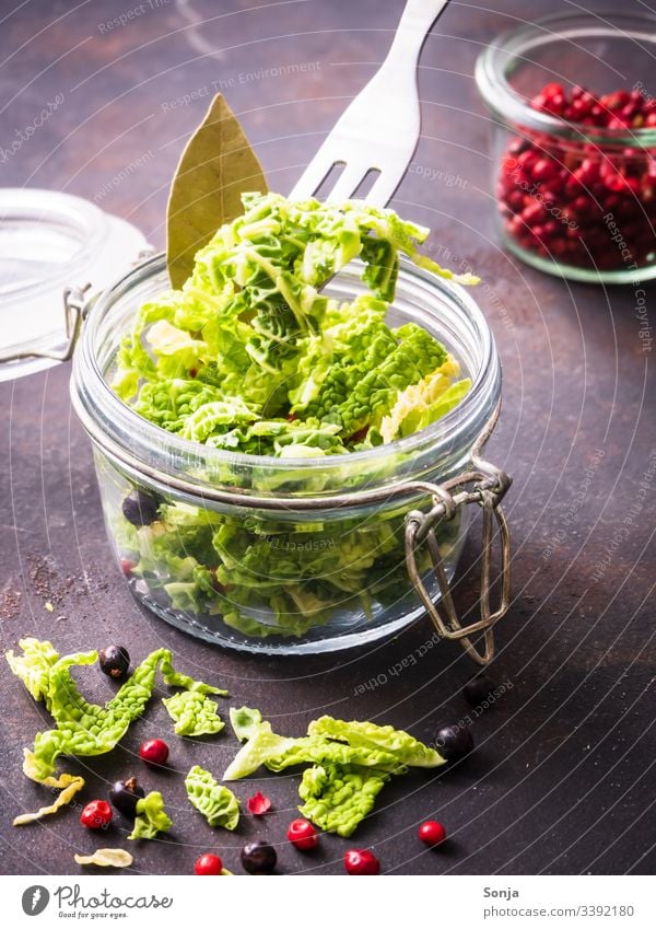 Roher geschnittener Kohl auf einer Gabel und in einem Einmachglas mit Gewürzen, eingemachtes Gemüse, gesunde Ernährung kohl einfüllen einmachglas diät Entzug