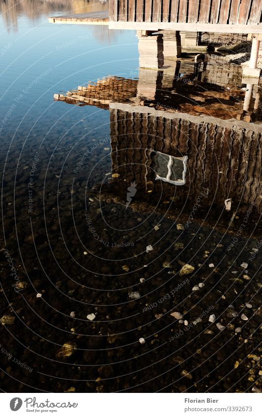 Spiegelung eines Bootshauses aus Holz im flachen Wasser eines Sees Haus Fenster Idylle Wohnen Natur Hütte flaches Wasser Holzbauweise Ferienhaus Anleger Ruhe