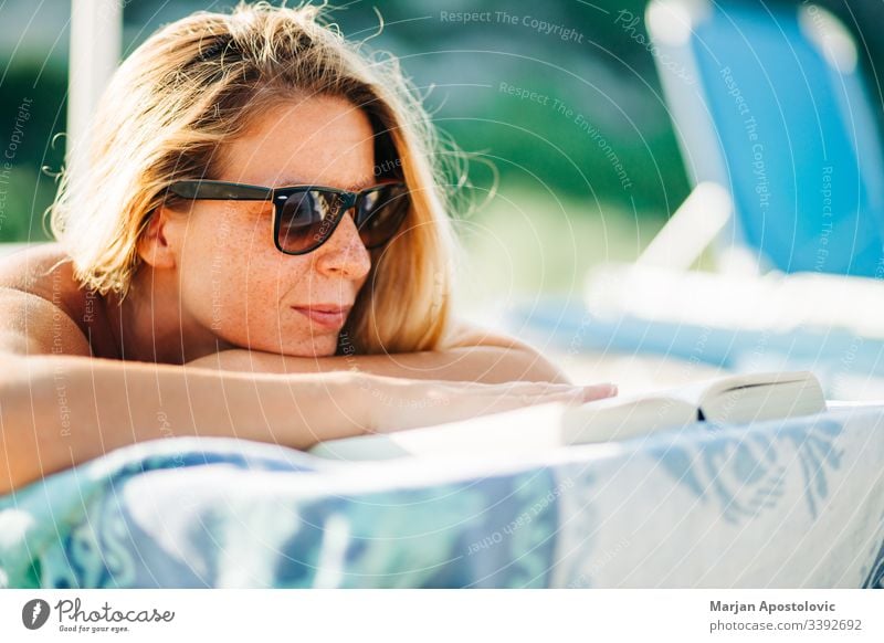 Junge Frau liest ein Buch am Strand liegend attraktiv schön Schönheit Bett blond lässig Kaukasier Nahaufnahme niedlich Tag genießen Sommersprossen Mädchen