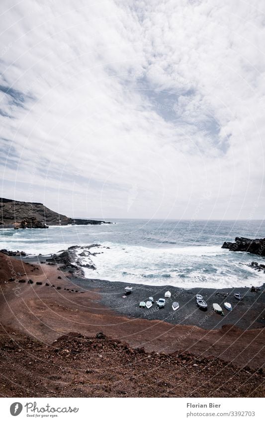 Felsiger Strand mit Fischerbooten und tosendem Meer Felsen Bucht Wasser Wellen gewaltig Stein felsig rauh tief Küste Landschaft Klippe Natur Aussicht Freiheit