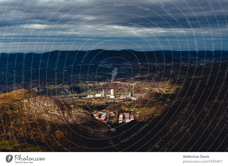 Erstaunliche Landschaft von der Hügelspitze des Industriebezirks und der Vorstadt in der Ebene gegen den Bergrücken am Horizont Stadt Fabrik Hochland Ambitus