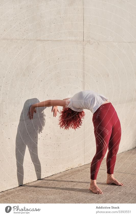 Frau macht Handstand beim Üben von Yoga auf der Straße Übung akrobatisch üben Gleichgewicht Training urban Athlet Barfuß Beton Gesundheit