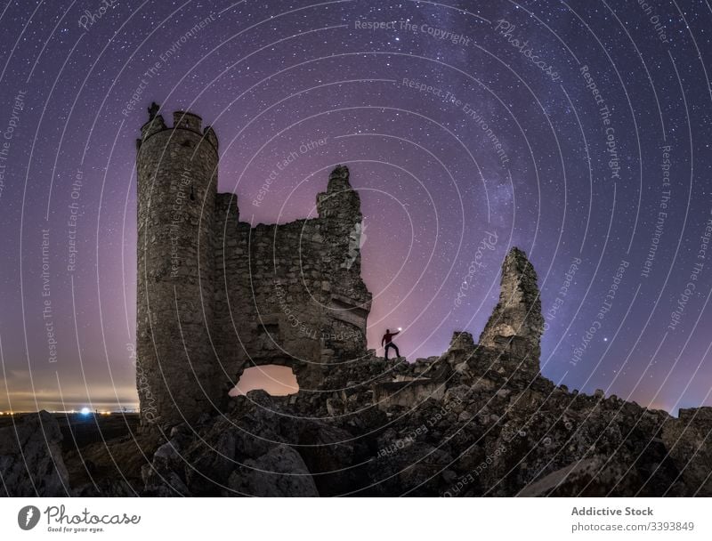 Gesichtsloser Reisender wandert nachts zur Burgruine wandern Burg oder Schloss Nacht Tourist erkunden ruiniert Laterne Sightseeing Milchstrasse sternenklar