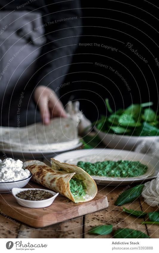 Fajitas aus gegrilltem Spinat, serviert mit Hüttenkäse und Sauce fajitas Tortilla Saucen Grillrost Tisch Bestandteil farbenfroh grün Speise Küche geschmackvoll