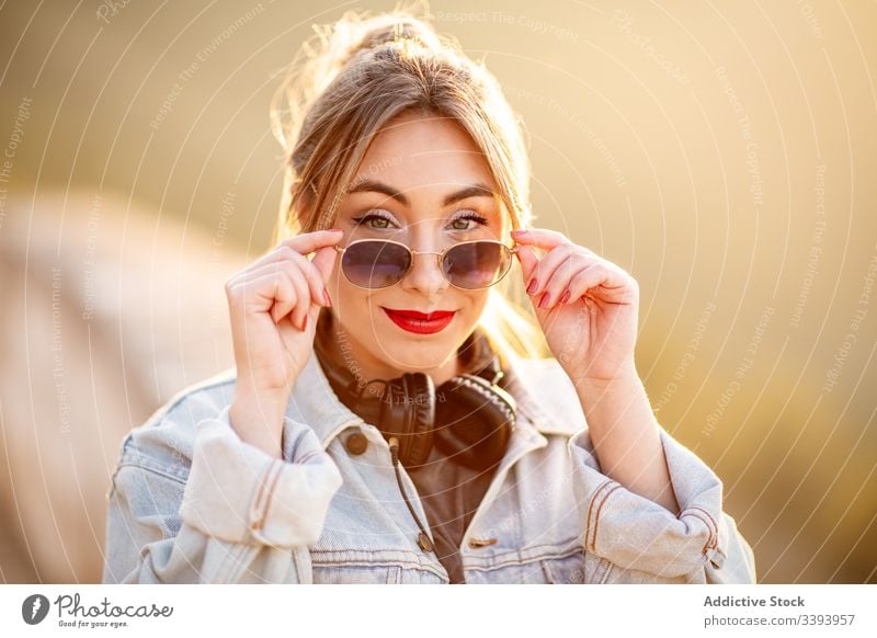 Stilvolle Frau in lässiger Kleidung erfreut sich am Anblick Lächeln genießen Sonne trendy Lifestyle Harmonie Mode ruhen sich[Akk] entspannen Outfit Wochenende