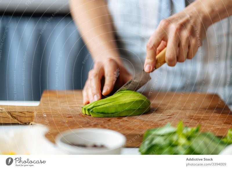 Frau schneidet Avocado auf Schneidebrett Lebensmittel Essen zubereiten Messer Schneiden Rezept Gemüse Bestandteil hinzufügen Gesundheit grün Küche Mahlzeit