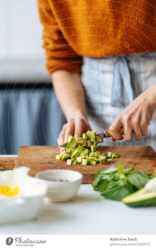 Frau schneidet gehackte Avocado auf Schneidebrett Lebensmittel Essen zubereiten Schneiden Rezept Gemüse Bestandteil hinzufügen Gesundheit grün Küche Mahlzeit