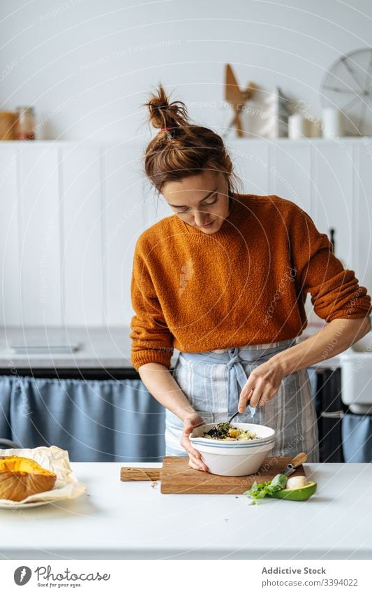 Frau gibt Rosinen in Schüssel Lebensmittel Essen zubereiten Rezept hinzufügen Schalen & Schüsseln Bestandteil Gemüse Gesundheit Korn Samen Küche Mahlzeit