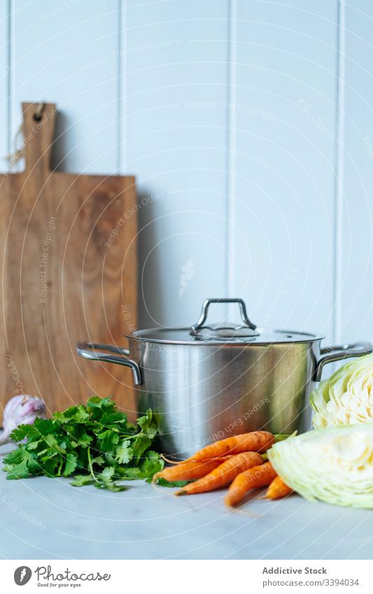 Frisches Gemüse und Kräuter in der Nähe des Kochtopfs Kraut Küche Speise Mittagessen Petersilie Möhre Kohlgewächse Lebensmittel Vorbereitung heimwärts Mahlzeit