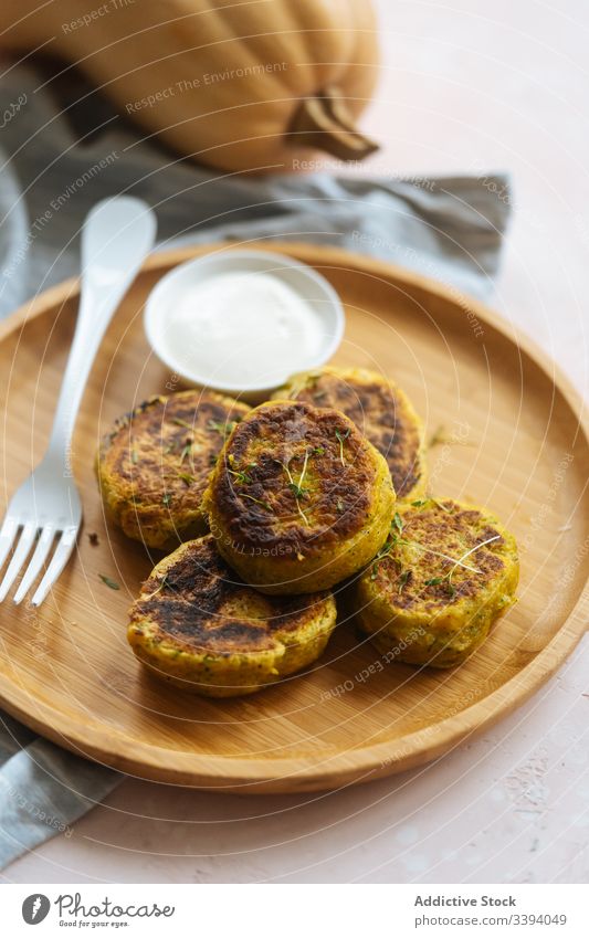 Köstliche Gemüseschnitzel mit saurer Sahne auf dem Tisch Kotelett Kürbis traditionell gebraten golden Küche Speise lecker Feinschmecker Teller Mahlzeit