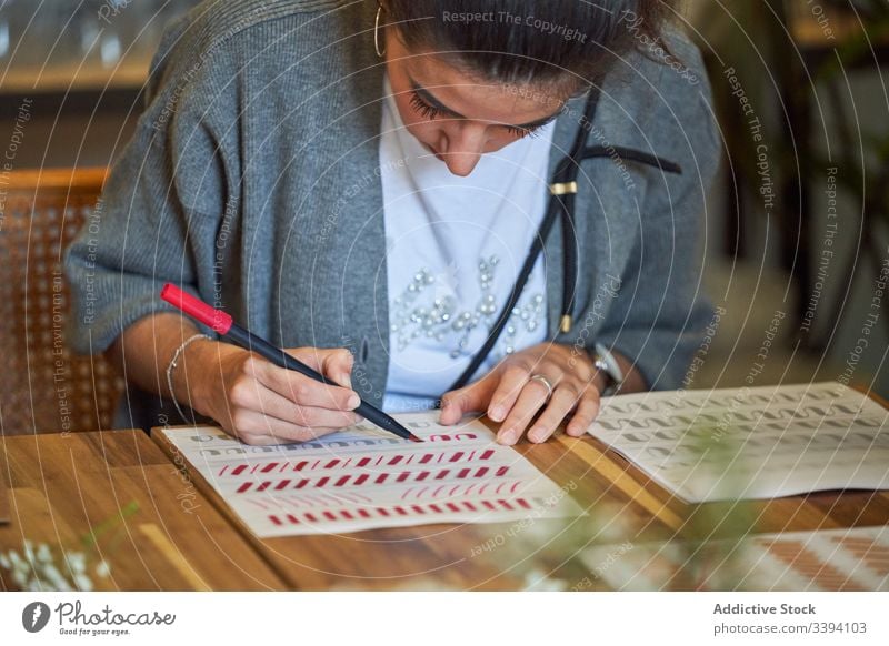 Künstlerin zeichnet mit Bleistift im Kunstatelier Frau Beschriftung Handschrift zeichnen Konzentration kreativ Fokus Lifestyle lernen Job sitzen Skizze