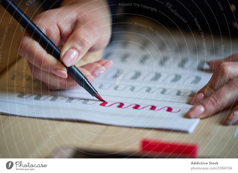 Gesichtslose Frau lernt Schriftzug bei Tisch Beschriftung zeichnen Papier Handschrift Beruf Schreibtisch Arbeitsplatz Kunst kreativ Handwerk graphisch Bildung