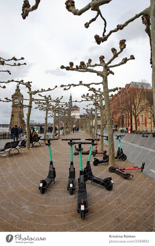 elektroroller am rathausufer in düsseldorf e-roller e-scooter leihroller elektroscooter pegeluhr schlossturm rheinufer rheinuferpromenade mobil mobilität