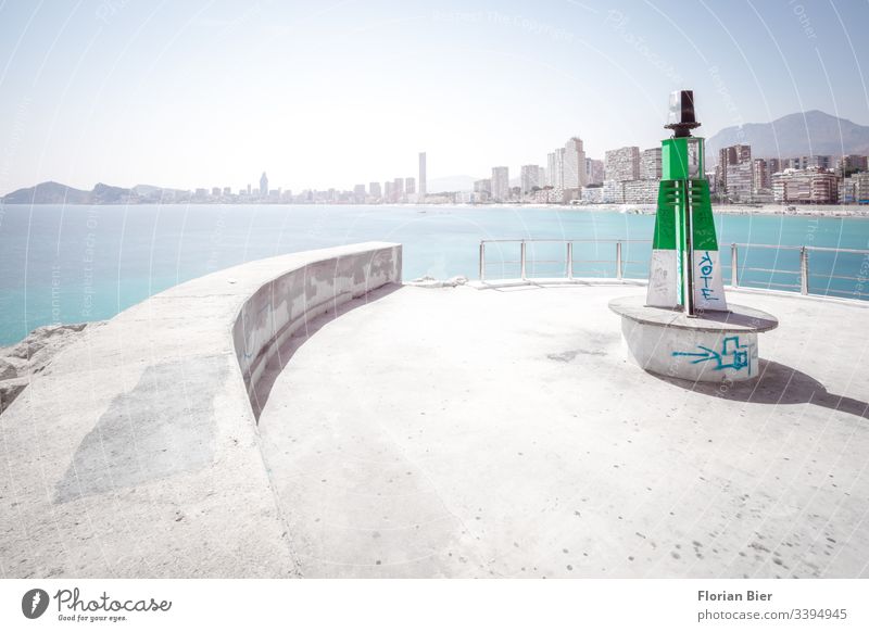 Leuchtturm im Hafen mit Blick auf Hochhaus-Strand-Panorama übers Meer Beton Skyline graffitti wohnen Hafenmohle Leben Sitzgelegenheit Mauer Signal