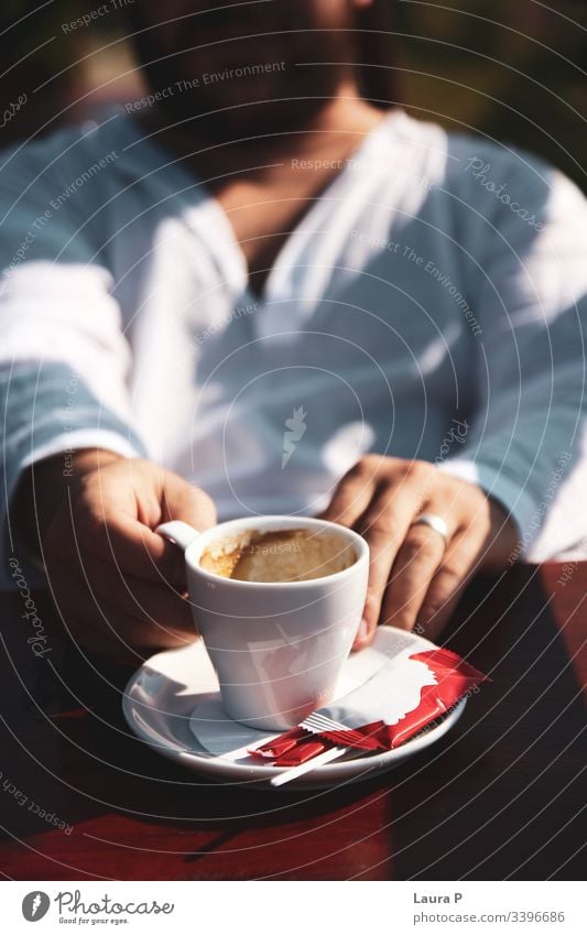 Mann in weißer Bluse mit einer Tasse Kaffee in der Hand abschließen Hände Beteiligung Cappuccino Espresso Getränke Morgen Frühstück sich[Akk] entspannen