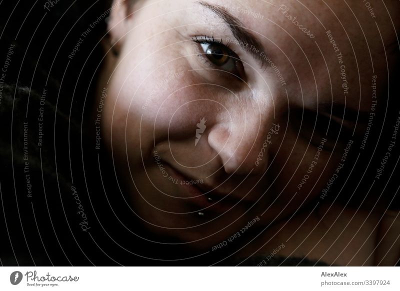 Portrait einer jungen Frau mit Lippenpiercing und Sommersprossen Blick nach vorn Porträt Zentralperspektive Schwache Tiefenschärfe Tag Nahaufnahme Innenaufnahme