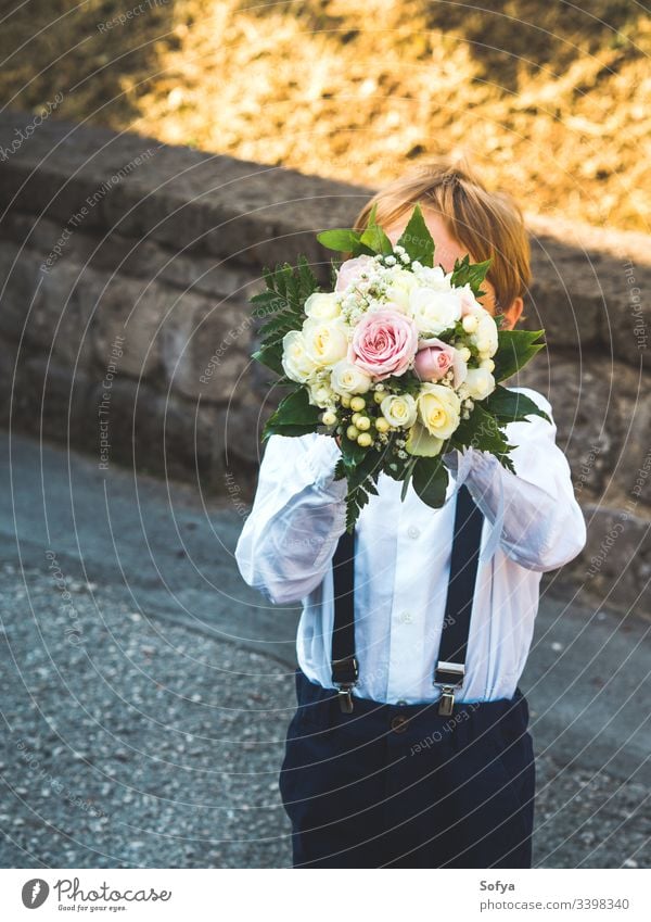 Ringträger bei Gartenhochzeit spielt mit Blumenstrauß Junge Hochzeit Junior striegeln Kind Sommer Porträt geblümt Mode Roséwein Natur Gesicht Sonne Glück schön