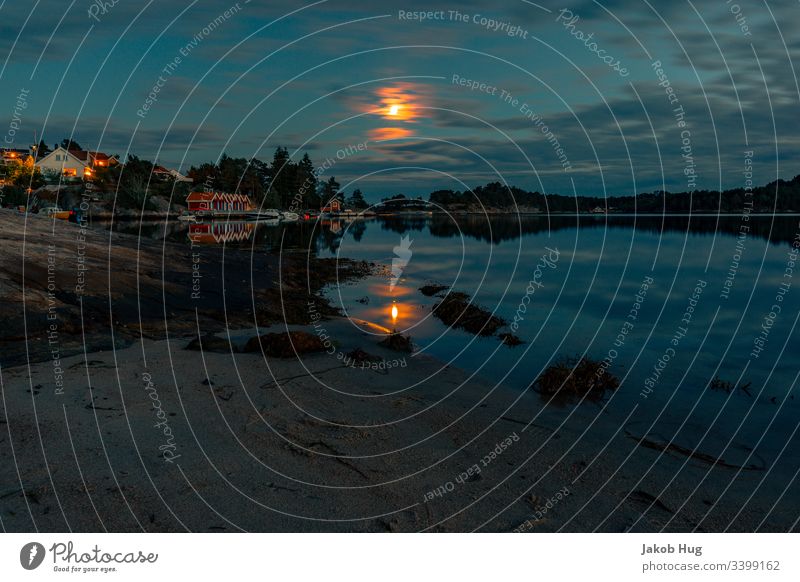 Mondlicht spiegelt sich im Wasser in einem See in Norwegen Küste Spiegelung Spiegelung im Wasser Abendrot glatt glatte Wasseroberfläche Meer Landschaft