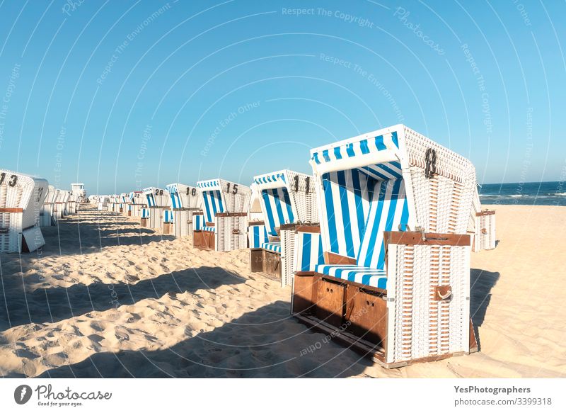 Strandkörbe in einer Reihe auf der Insel Sylt. Meeresstrand an einem sonnigen Tag Friesische Insel Schleswig-Holstein Wattenmeer ausgerichtet Blauer Himmel