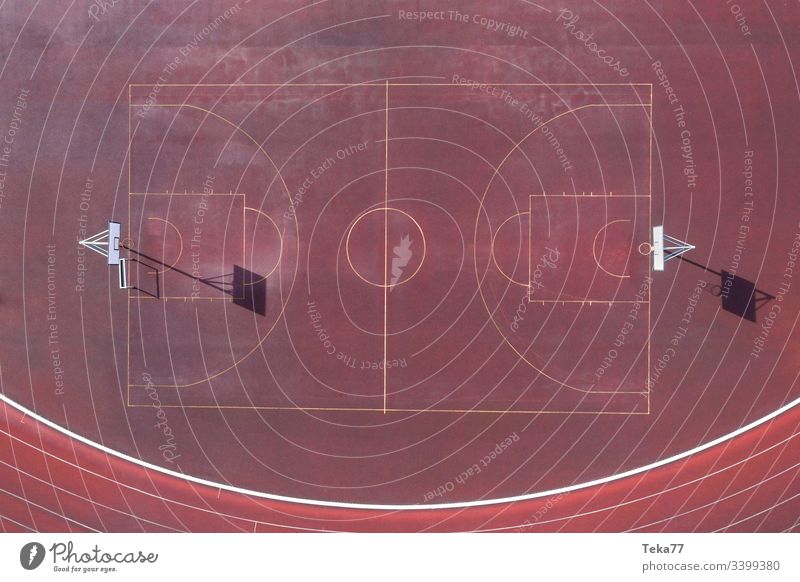 ein einfacher Basketballplatz von oben Basketballfeld Linien Sport-Linien Basketball-Linien Sportplatz Asche rot kleiner Basketballplatz Sonne Schatten Ball