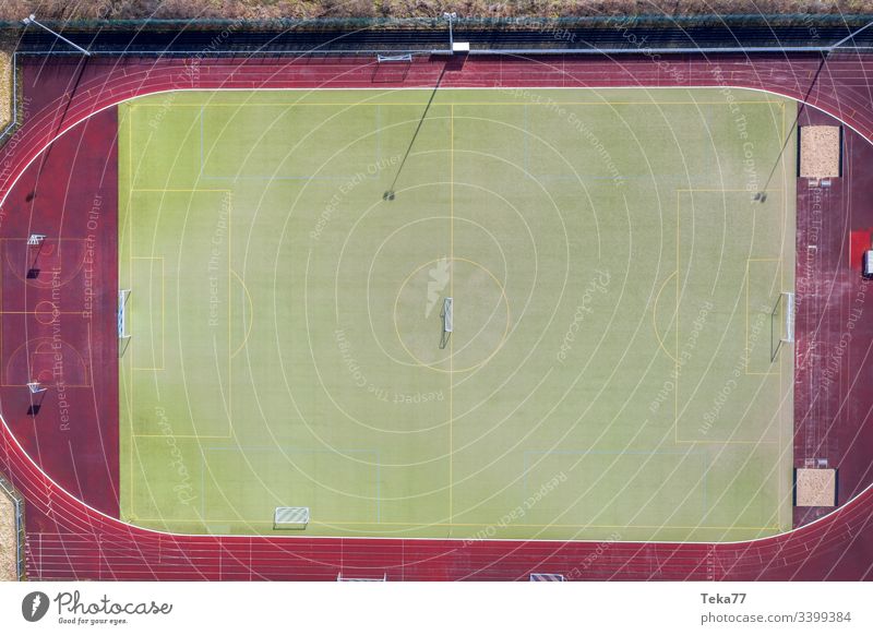 ein Fußballfeld von oben Fußballfeldtor Fußballtor Linien Sport Sportplatz grün kleiner Fußballplatz Gras Sonne Schatten Laufbahn rennen Aschefeld