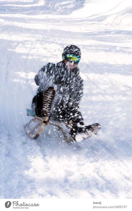 Nicht erkennbarer Mensch hat im wild spritzenden Schnee viel Spass beim Rodeln spaß-faktor Spaß schnee Winter Außenaufnahme kalt Freizeit & Hobby Sport