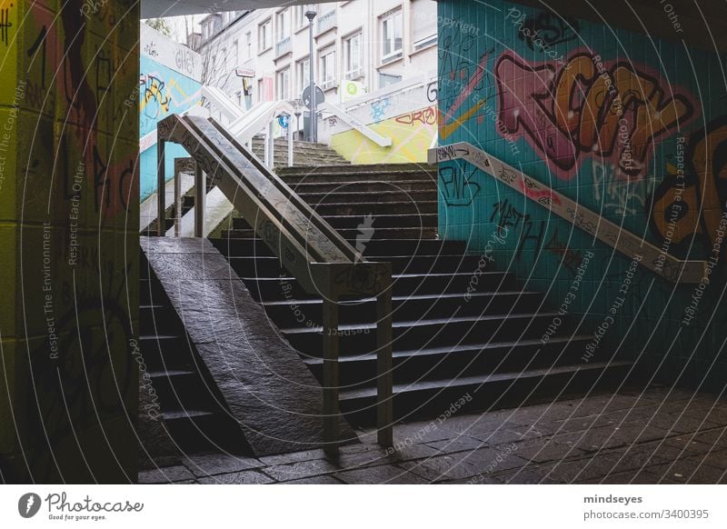 Treppe mit Graffiti Treppengeländer dunkel urban Stadtansichten Unterführung Darmstadt Großstadt Pfeil Farben taumeln dunkel und düster bunt gemischt