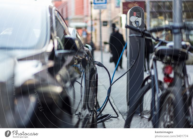 Das Aufladen moderner Elektroautos auf der Straße als Zukunft der Automobilindustrie. elektrisch PKW Fahrzeug Gebühr Verkehr Technik & Technologie Industrie