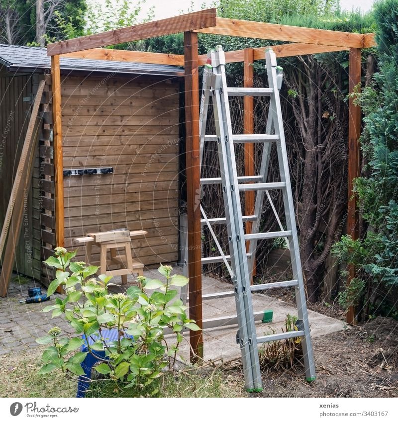 Baustelle im Garten mit Leiter Pergola Holzbau Schemel Bohrmaschine arbeiten Pflanze Natur Handwerk Werkzeug Hortensie DIY selber machen Hocker Sitzplatz