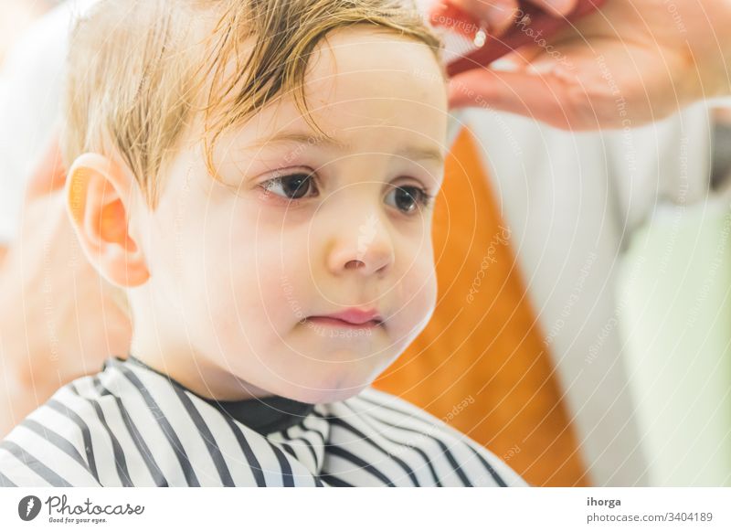 der kleine Junge in einem Friseursalon bezaubernd Baby Barbershop Schönheit blond Pflege Kaukasier Stuhl Kind Kindheit Kinder Kamm geschnitten niedlich Gesicht